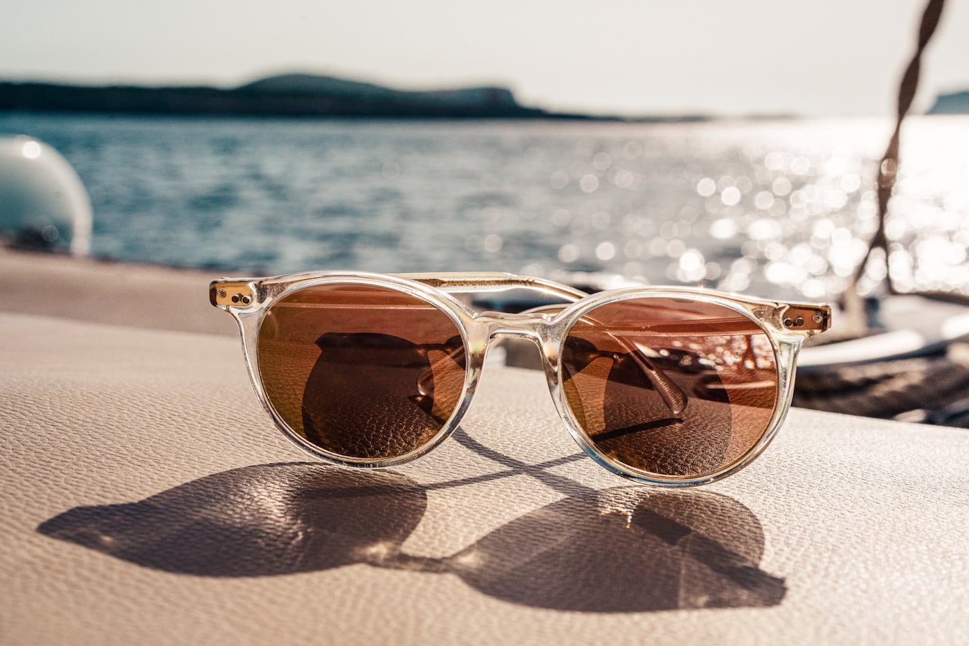 Designer sunglasses on a sunlit table by the sea